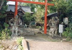 朱色の鳥居の手前両側に立つ仁王像の写真