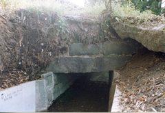 細い水路に平な石が積まれている、石造りの大平落中橋の写真