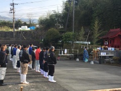 右側にお供え物と神主、左側に整列して頭をさげる参加者たちが写っている写真