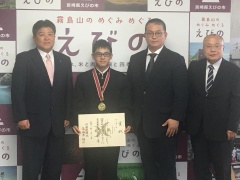 首に金メダルをかけた中武くん、市長、関係者達が並んでいる写真