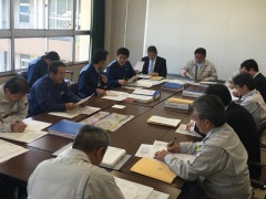 長机の上に沢山の資料が置かれていて、机を囲むようにえびの市長、関係者達が座って会議をしている写真