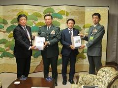 屏風の前に立ち要望書を持っている男性4名の写真