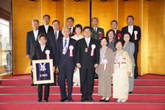 屏風を背景に表彰者と市長の集合写真