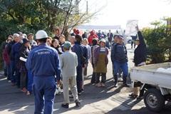 多くの参加者が集まっており、参加者に話をしている帽子を被った男性と消防服を着てヘルメットを被った男性の写真
