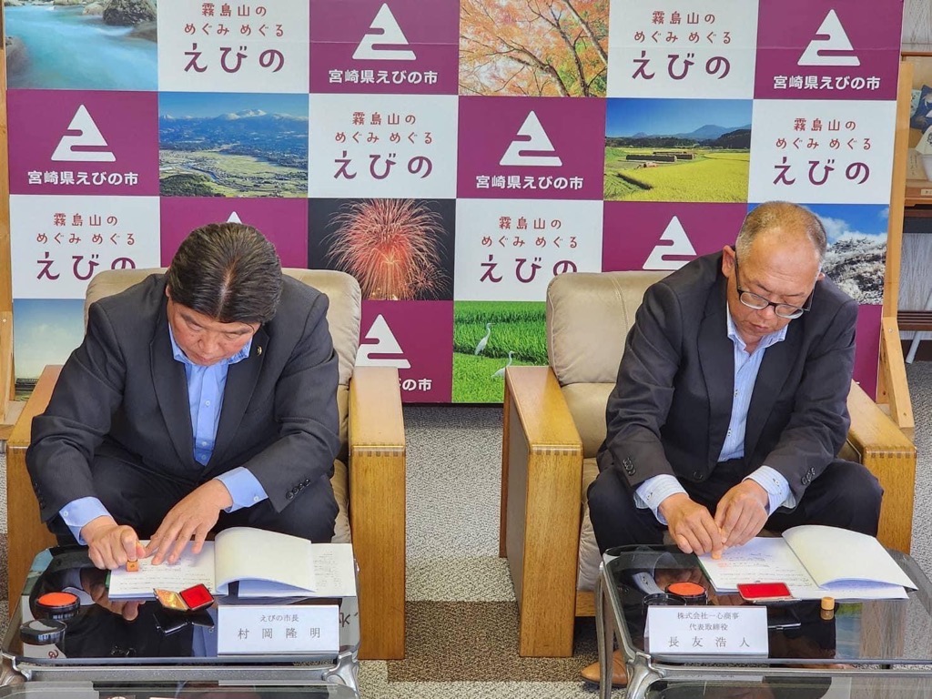 協定書に調印する市長と長友社長