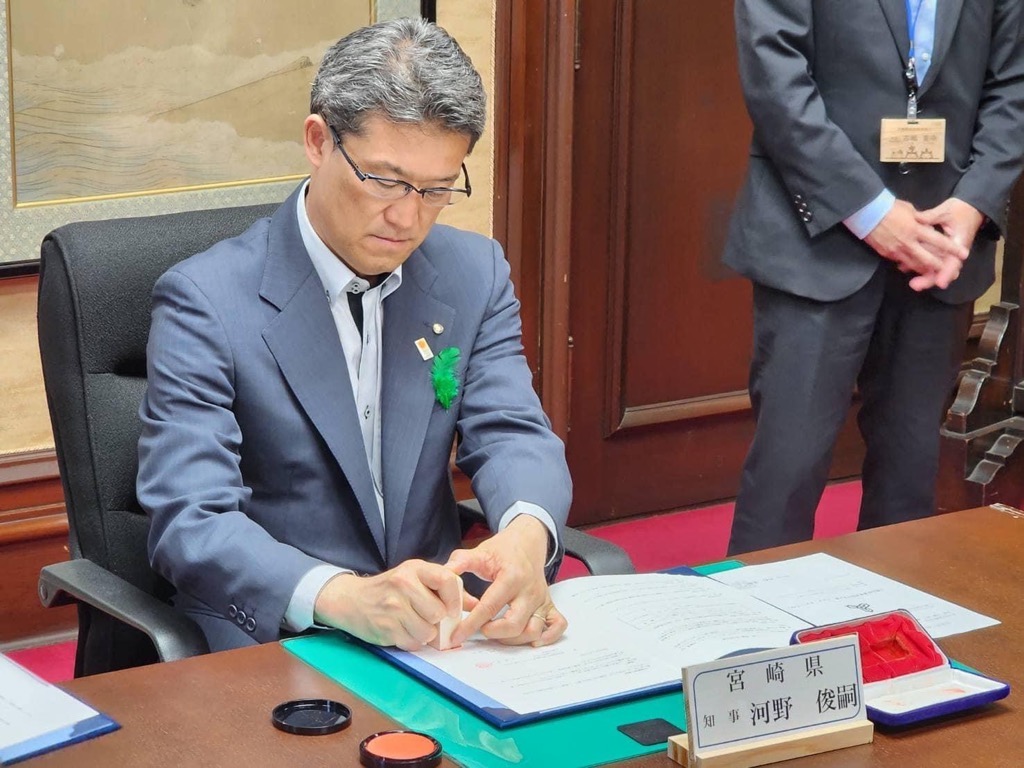 調印する県知事