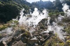 岩場の複数の箇所から白い蒸気が噴き出している白鳥温泉地獄の写真