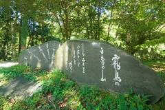 緑の中に与謝野鉄幹・晶子の「霧嶋のうた」が刻まれた文学碑の写真