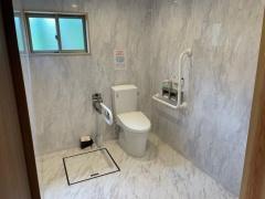 薄いグレー色の壁のバリアフリー対応のトイレの写真