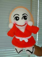 赤い着物に草履を履いたえびの市マスコット「みなほ」のパペット人形の写真