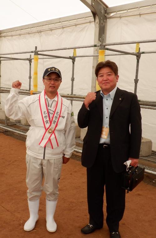 表彰式後ガッツポーズをする神田譲市さんと村岡隆明市長