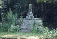 木々に覆われた林の前に設置された鶴寿丸の墓の写真