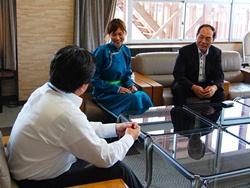モンゴル衣装を着た永田さん、JICAの日高さんが椅子に座って市長と話をしている社員