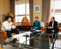 左にえびの市長、中央に永田さん、右に日高さんが座っていて市長が両手を開いて話をしている写真