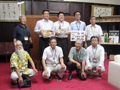 河野宮崎県知事、えびの市長、周りに7名の関係者たちが並んでいる記念写真
