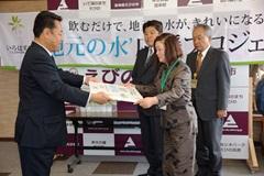 南九州コカ・コーラボトリング株式会社の代表者が西諸地区森林組合の代表者へ目録を渡している写真