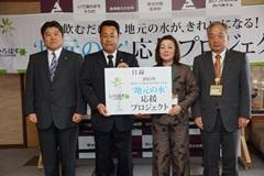 南九州コカ・コーラボトリング株式会社の代表者、西諸地区森林組合の代表者、えびの市長が並んでいる写真