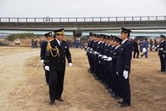 右側に制服を着た消防隊員が横一列に並んでいて、消防隊の前を制服姿のえびの市長が歩いている写真