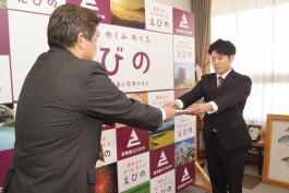 市長がスーツの男性に品物を渡している写真