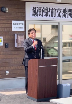 飯野駅前交番の前の講演台でマイクを持って話をしている市長の写真