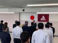 日本国旗とえびの市章の前に立っている市長と向かい合い、整列して立っている多数の職員の写真