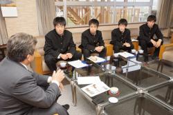 えびの市長と学生服を着た飯野高校の学生4人が椅子に座って話をしている写真