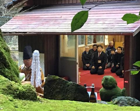 玉串ほうてんをしている神主と神社内で座っている市長や参加者の写真