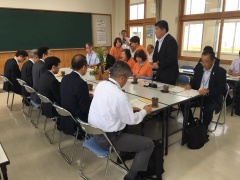 スーツやオレンジ色のシャツを着た関係者が、着席している中、立って発言をしている市長の写真