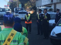 交通安全のたすきをかけた市長がマイクを持って話をしている写真