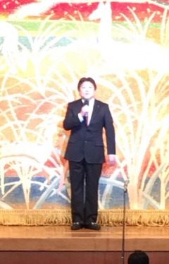 幕が下りた舞台上に立つ市長の写真