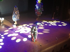 舞台上の衣装を着た出演者にライトが照らされている写真