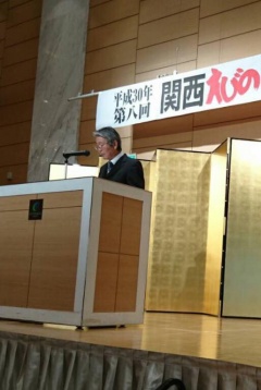 関西えびの会で、演台に立つ男性の写真