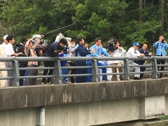 市長と関係者と取材陣が橋の上に立ち、下を見下ろしている写真