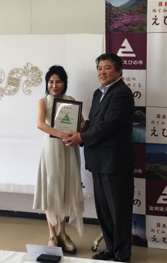 額に入った委嘱状を持つ藤山邦子さんと市長の記念写真