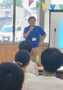 青いポロシャツ姿の市長が南九州会議の参加者たちに向けて話をしている写真