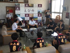 奥に市長、手前に加久藤少女バレー部の選手達、間に関係者たちが座って話をしている写真