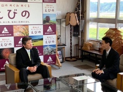 椅子に座ったえびの市長と鈴木尚洋隊員が向かい合って話をしている写真