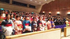 振袖の女性や、袴、スーツの成人者が、観客席で立っている写真