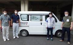 えびの市災害支援車両と書かれた紙が貼られた車両と、その横に立つ4名の男性の写真