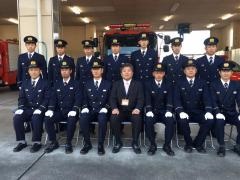 消防車の前で前段は座り、後段は立っている消防署職員と市長の集合写真