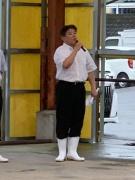 白い長靴を履いた市長が品評会でマイクを持って話をしている写真