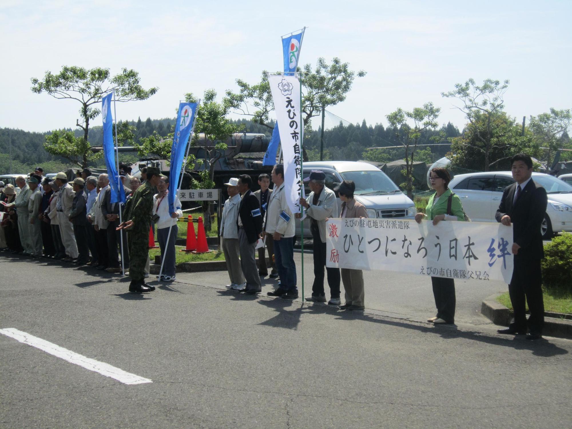 横断幕や旗を持って並ぶ市民の写真