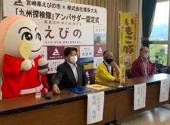 長机に着席している市長と法被を着た2名の男性、市長の横に立っているマスコットキャラクターが写っている写真