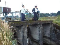 スーツを着た市長と、男性が河川の状況を見ながら話をしている写真