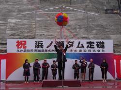 浜ノ瀬ダム定礎式にて、舞台上でリボン記章を付けた市長が万歳三唱をしている写真