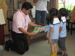 市内幼稚園の園児2名から絵が描かれたメッセージを受けとる市長の写真