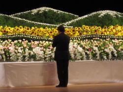 花祭壇の前で手を合わせる市長の後ろ姿の写真