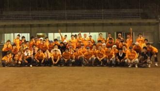 焼肉スタジアム運営スタッフが、オレンジ色のシャツを着て並んでいる集合記念写真