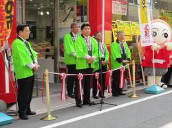 緑の法被を着た市長や関係者が、テープカットの前に立っている写真